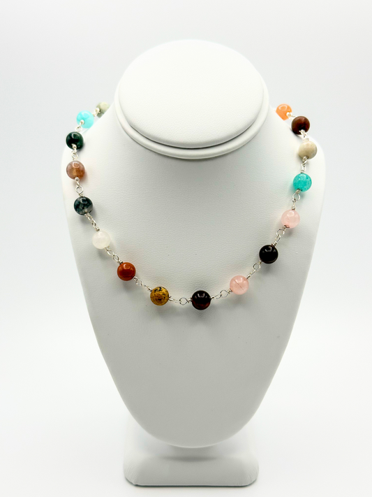 Mixed Stone Necklace displayed on white, upper small chest display, white background. 